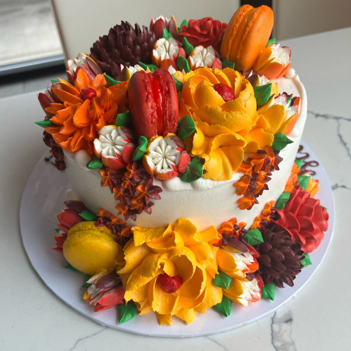 autumn cake with orange yellow and red flowers and macarons
