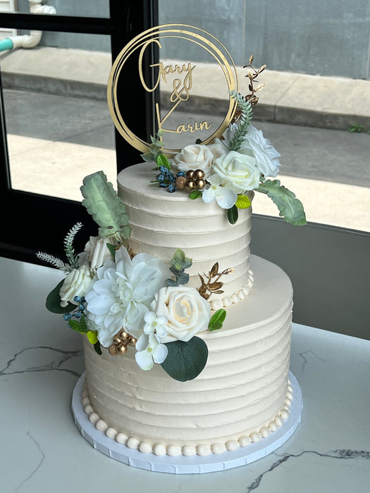 2 tier wedding cake with white and light blue flowers