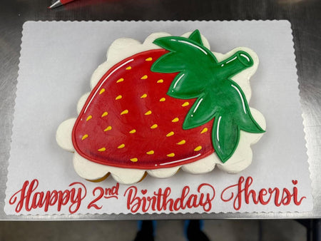 Strawberry-shaped birthday cake with on a white background