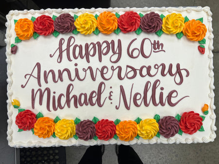 Anniversary sheet cake with orange, red and yellow flowers