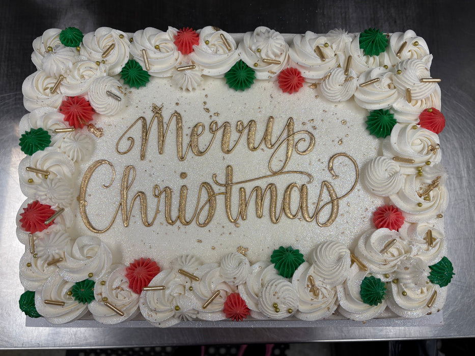 Christmas-themed cake with 'Merry Christmas' text and decorative icing on a metal surface.