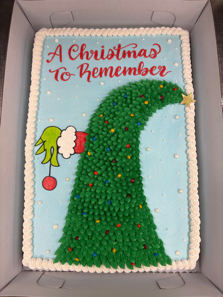 Christmas-themed cake with Grinch design and text 'A Christmas to Remember' on a blue background.