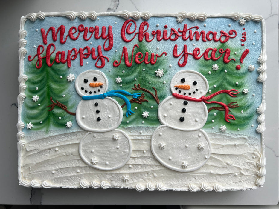 Christmas cake with snowmen, trees, and 'Merry Christmas Happy New Year' text.